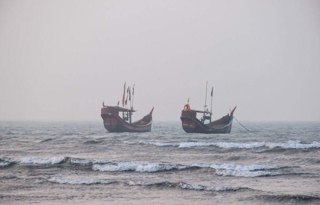 a couple of boats floating on top of a large body of water